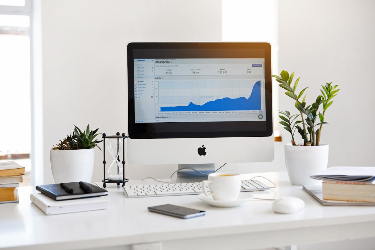 The Art of Drawing Readers In: Your attractive post title goes here A clean, contemporary workspace featuring a desktop with analytics on the screen and plants for a fresh look.