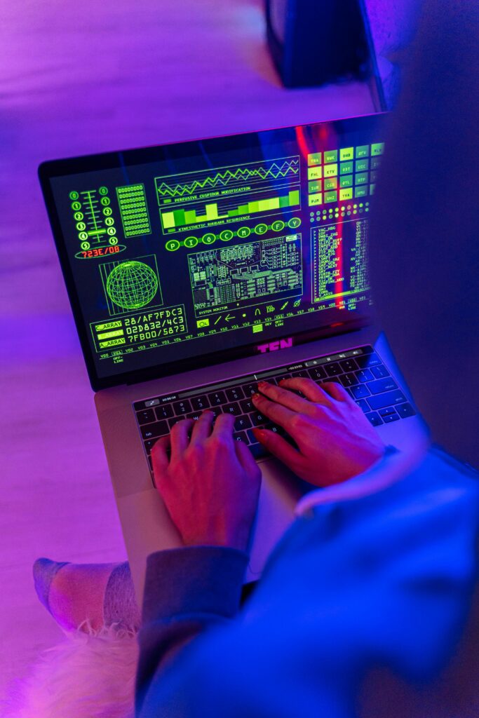 pexels photo 5475760 5475760 An unrecognizable person using a laptop indoors with digital screens displaying data and analytics.
